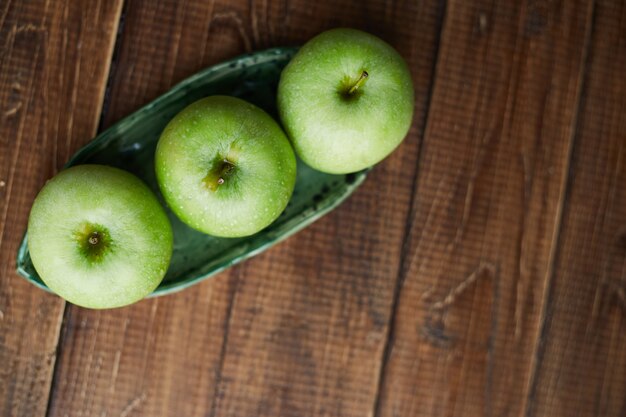 Groene appels op houten tafel. Detailopname. Concept van gezonde voeding. Gesneden groene appel op snijplank