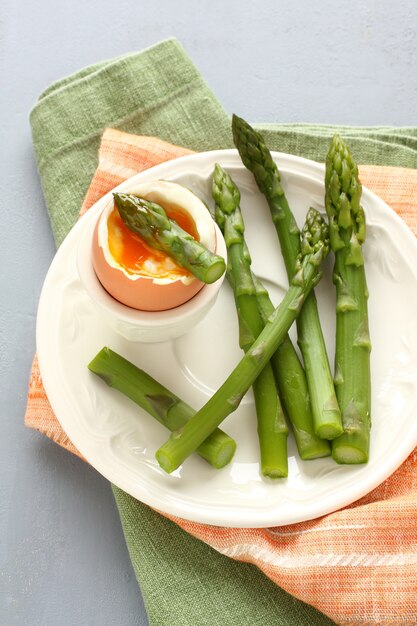 Groene asperge met zacht gekookt ei op witte plaat