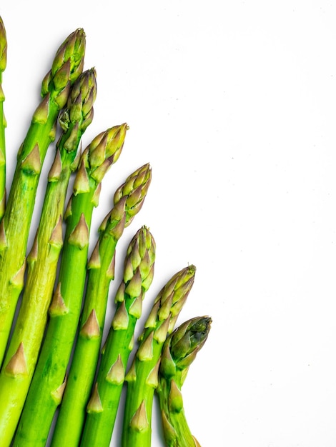 Groene asperges die op witte exemplaarruimte worden geïsoleerd