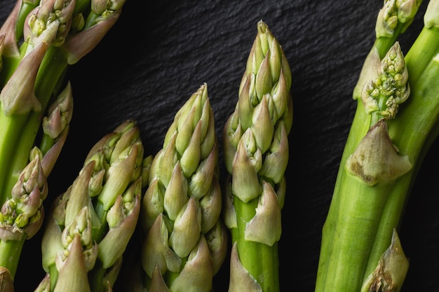 Foto groene asperges op een zwarte achtergrond met kopieerruimte