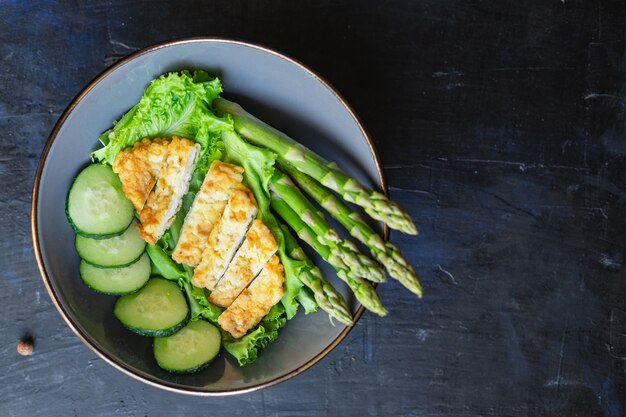 Groene aspergesalade kippenvleeskom groene saladebladeren die biologisch dieet op tafel eten