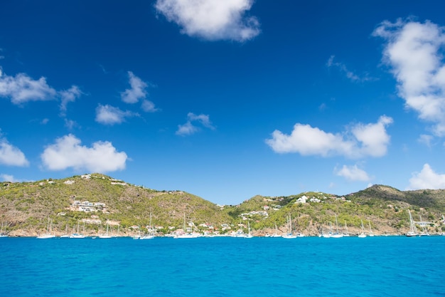 Groene berg met jacht, boot, scheepsvervoer in baai of haven met zee, oceaanwater en blauwe bewolkte hemel zonnige zomer als natuurlijke achtergrond. reizen en vakantie, zeilen