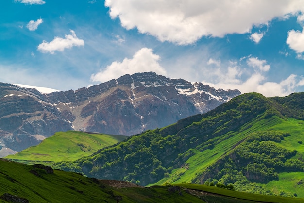 Groene bergen en blauw wolkenlandschap