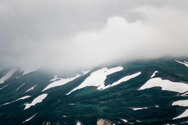 Groene bergen met sneeuw en wolken Vilyuchinsky-pas in Kamtsjatka Rusland