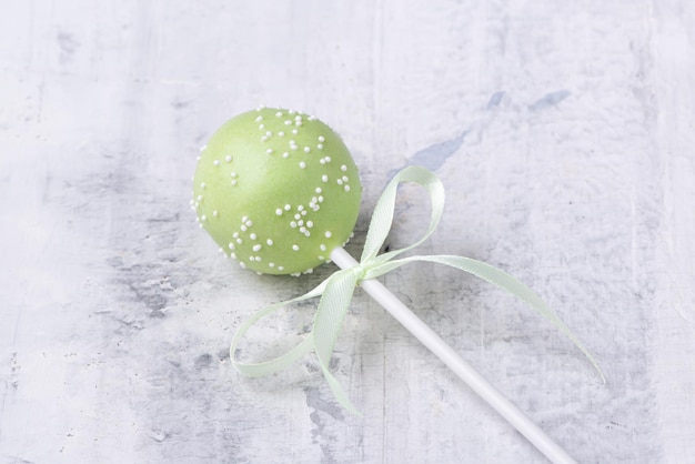 Groene cakepop op een gestructureerde achtergrond