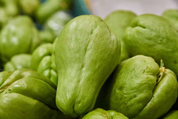 Groene chayotes geplaatst op een plank voor verkoop in een markt