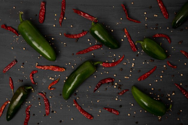 Foto groene chilipepers en rode chilipepers op een grijze tafel