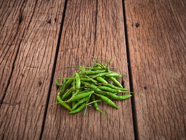 Groene chilipepers op houten