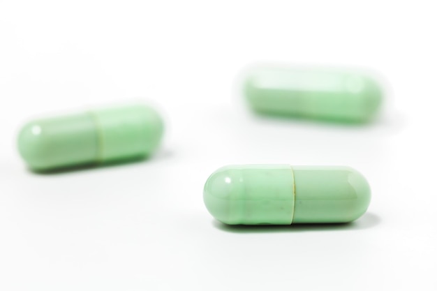Groene chiretta-kruidencapsule op witte achtergrond met exemplaarruimte voor gezondheidszorg en medisch concept