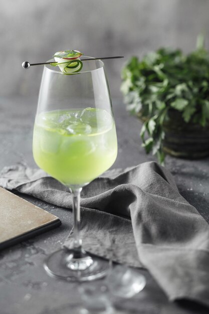 Foto groene cocktail met een plakje komkommer in de buurt van peterselieblad