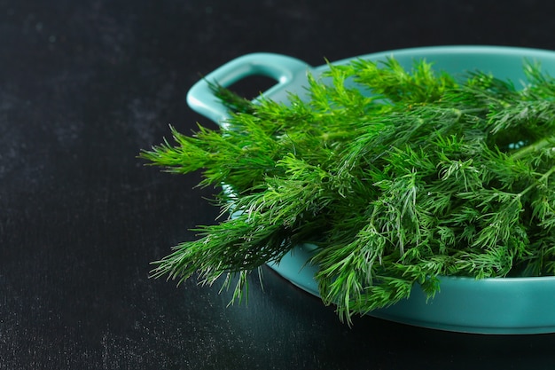 Groene culinaire kruidendille in een blauwe schotel