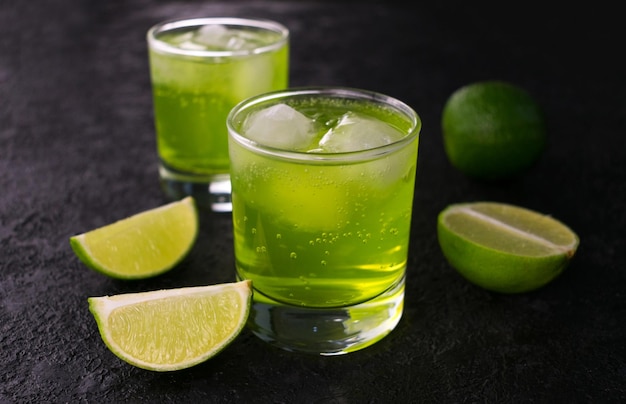 Groene drank met limoen en ijs op een zwarte achtergrond