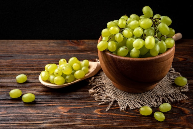 Groene druiven op een houten kom op tafel