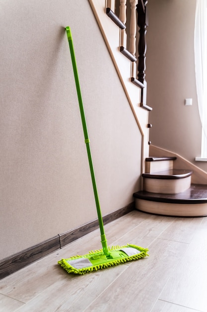 Groene dweil op een muur en trappen achtergrond. Woonkamer schoonmaken.