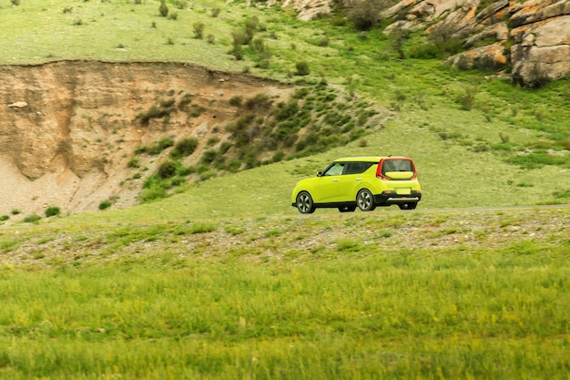 Groene elektrische auto rijden langs een bergweg op een zonnige dag concept eco-auto