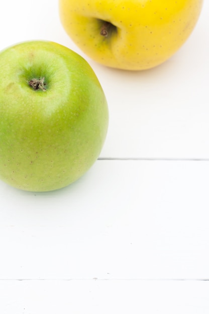 Groene en gele appels op een witte houten close-up als achtergrond