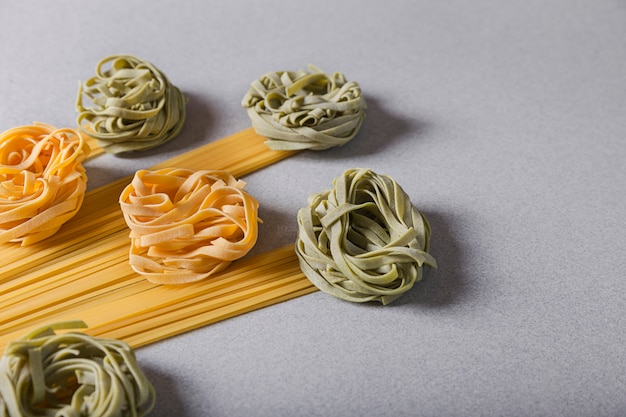 Groene en gele Tagliatelle en Spaghetti op achtergrond