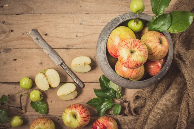 Foto groene en rode appels op rustieke tafel. plat leggen