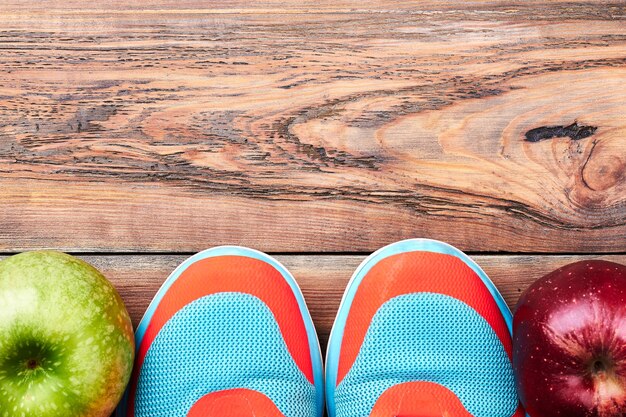 Groene en rode appels. Sneakers op houten oppervlak. Sport maakt je leven gezond.