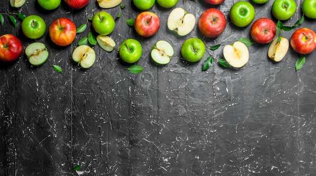 Groene en rode sappige appels met loof en appelschijfjes