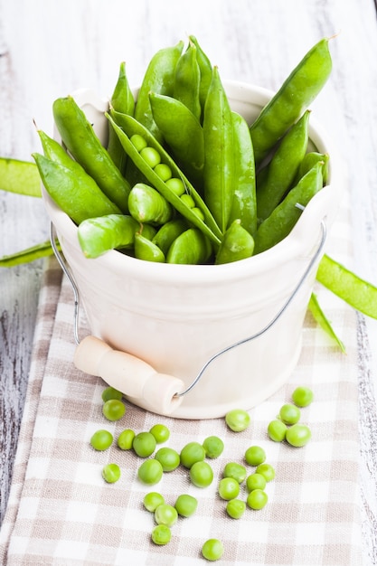 Groene erwt verspreid over het servet en ongeschilde erwt