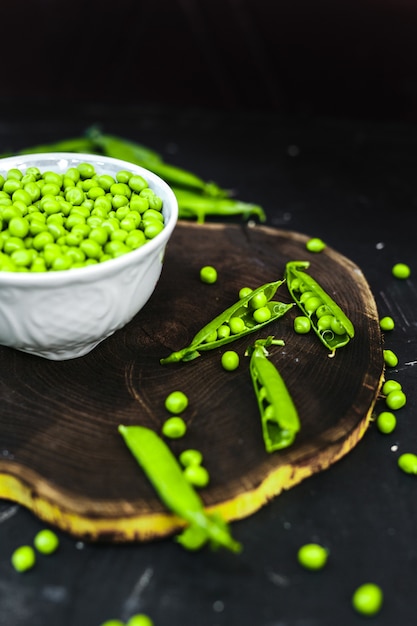 Groene erwten en verse korrel op een oude houten lijst.