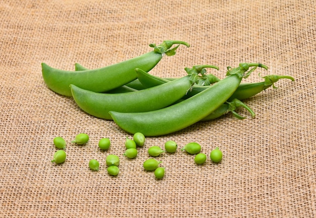 Groene erwten op zakachtergrond