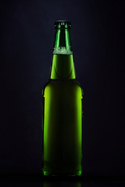 Groene fles bier op een donkere achtergrond