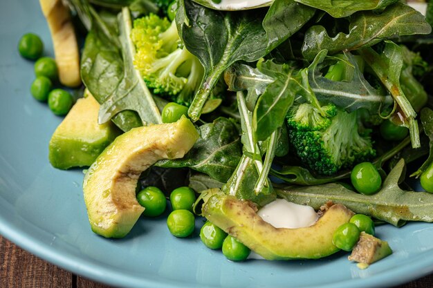 Groene gezonde spinaziesalade met avocado en doperwten