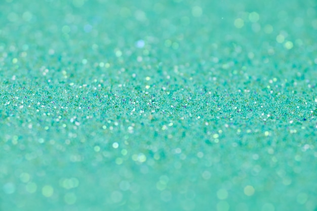 Groene glitter textuur. nieuwjaar of kerstmis achtergrond voor wenskaart. valentijnsdag viering. glanzend sprankelend ontwerp voor feestelijke decoratie: bruiloft, vakantie of jubileumfeest.