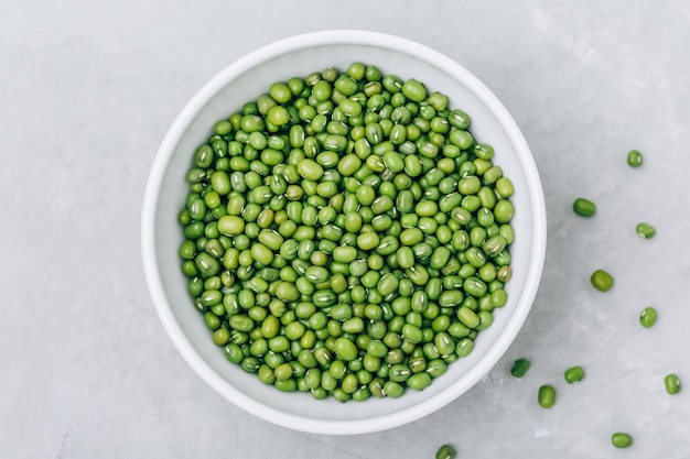 Groene gram biologische mungbonen in kom op grijze stenen achtergrond