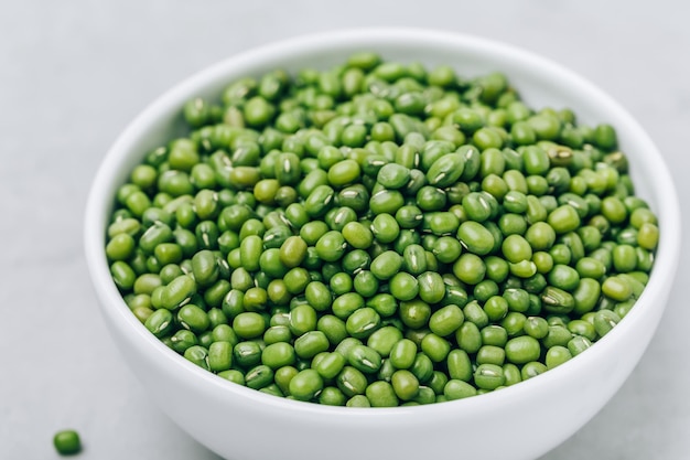 Groene gram biologische mungbonen in kom op grijze stenen achtergrond