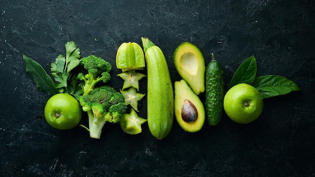 Groene groenten en fruit Gezonde voeding op zwarte stenen achtergrond Tropisch fruit Bovenaanzicht Vrije ruimte voor uw tekst