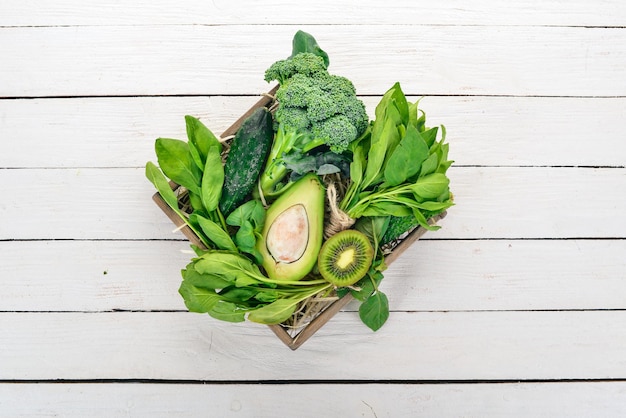 Groene groenten en fruit op een witte houten achtergrond Gezonde voeding Bovenaanzicht Ruimte kopiëren