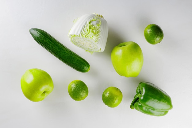 Groene groenten en fruit op witte achtergrond. Gezond vegetarisch voedselconcept. Bovenaanzicht