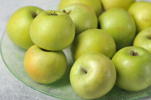 Groene hele sappige appels op een plaat