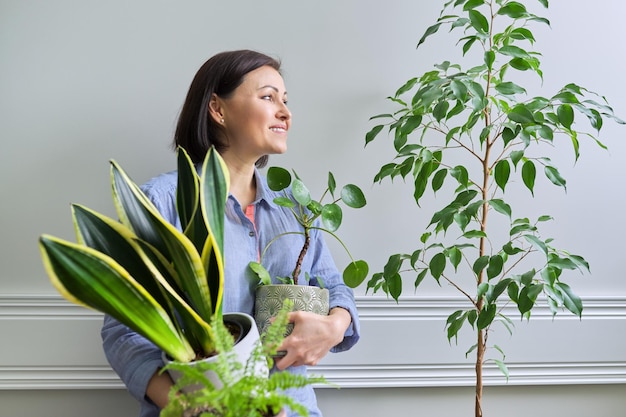 Groene hobby kamerplanten voor binnen vrouw met planten in potten