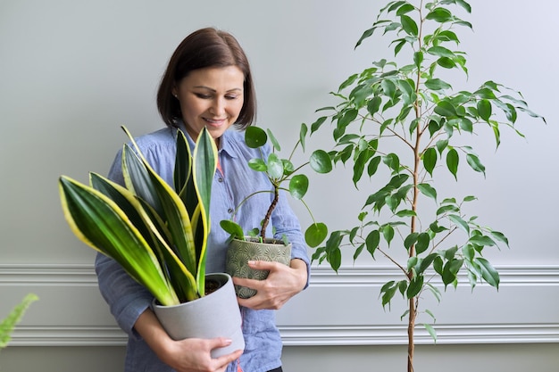 Groene hobby kamerplanten voor binnen vrouw met planten in potten