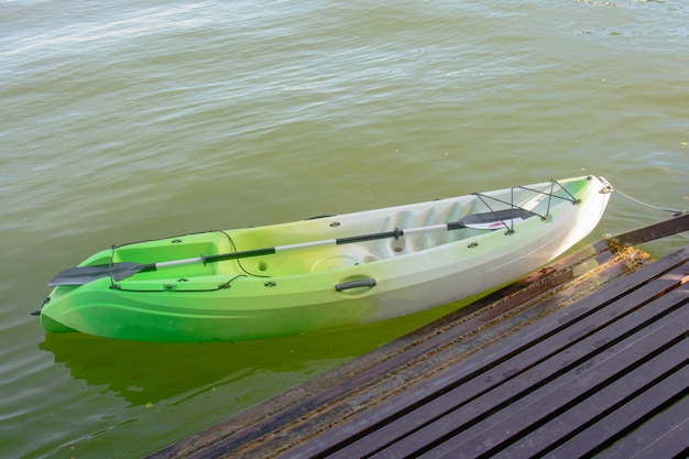 Groene kajak op de rivieroever