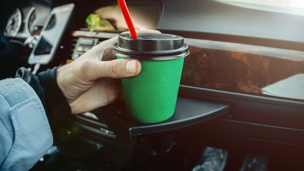 groene kartonnen kop koffie in de auto in de handen drankje op de reis