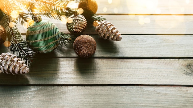 Groene kerstbal met dennentakken en ornamenten op houten achtergrond met kerstverlichting bokeh