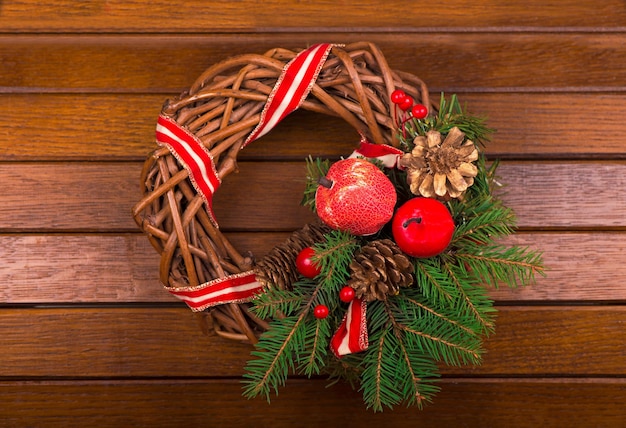 Groene kerstkrans met versieringen op houten achtergrond