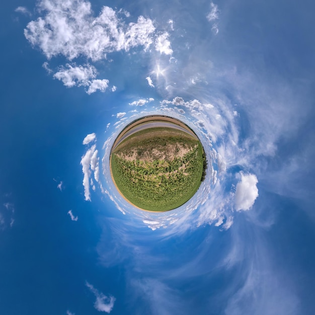 Groene kleine planeet in blauwe lucht met prachtige wolken Transformatie van bolvormig panorama 360 graden Bolvormige abstracte luchtfoto Kromming van de ruimte