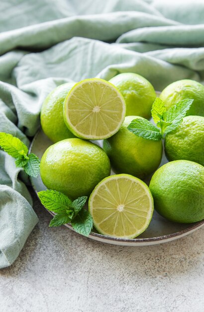 Groene limoenen met verse muntblaadjes op bord