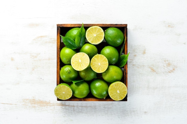 Groene limoenen op witte houten achtergrond fruit bovenaanzicht vrije ruimte voor uw tekst