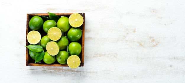 Groene limoenen op witte houten achtergrond Fruit Bovenaanzicht Vrije ruimte voor uw tekst