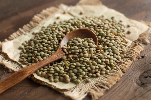 Groene linzen met een lepel op een houten tafelblad-weergave