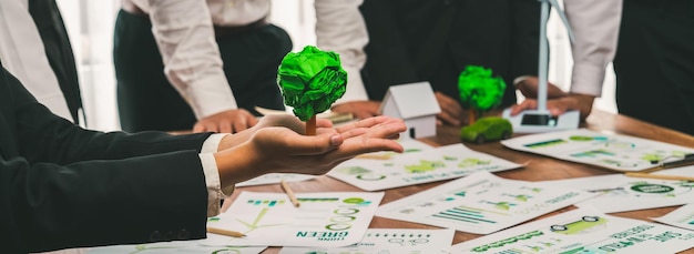 Groene, milieuvriendelijke zakenlieden met milieuaansprakelijkheid bijeenkomst over herbebossing en alternatieve duurzame energiebenutting Ondernemer houdt papierboom in vergaderzaal