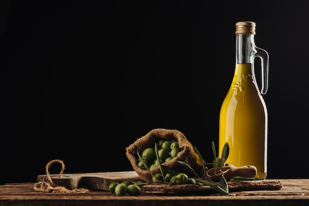 Groene olijven en olijfolie in een fles close-up