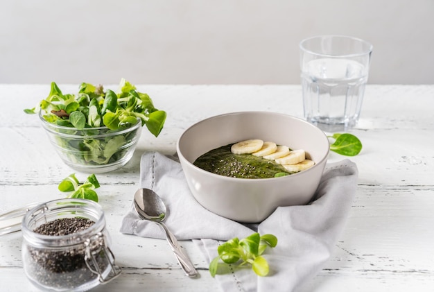 Groene pap of smoothie in kom met hoofdingrediënten chiazaad groen water